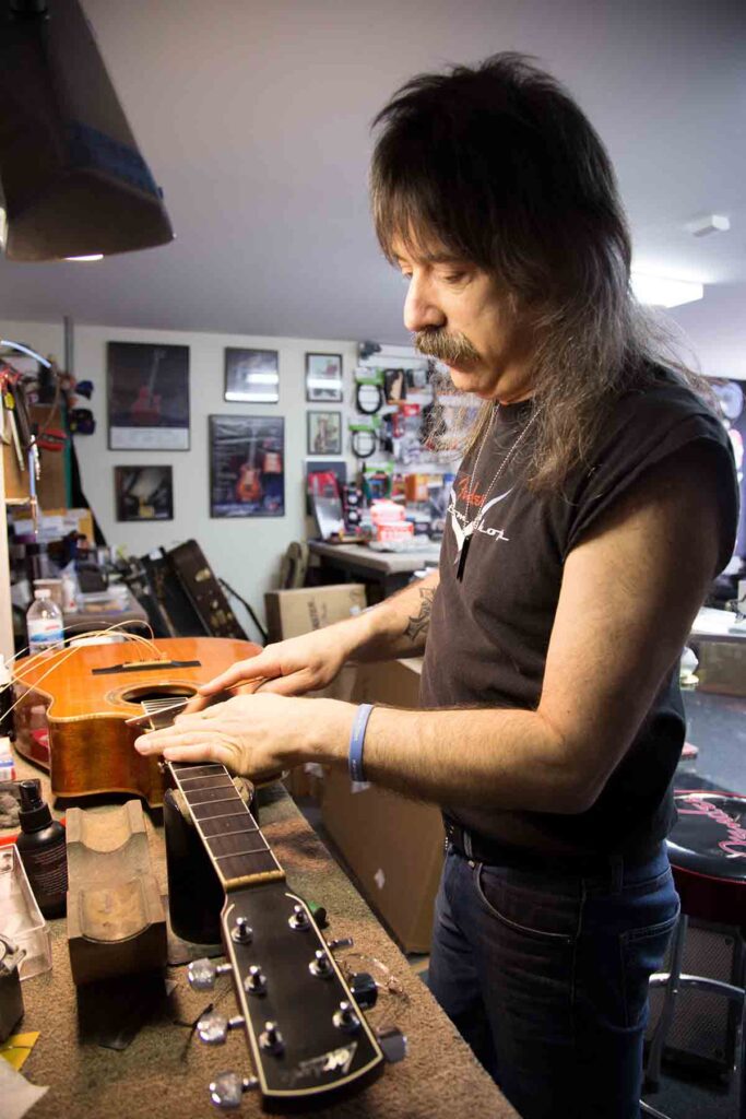 John Carlino repairing an acoustic guitar